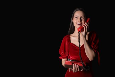 Siyah arka planda retro telefonu olan güzel bir genç kadının portresi.