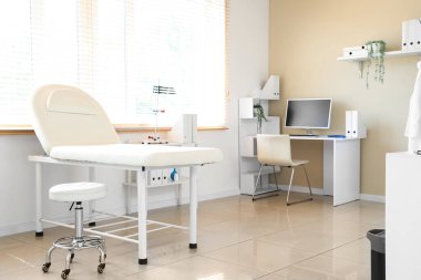 Modern çalışma yeri ve kanepesi olan doktorun ofisinin içi aydınlık.