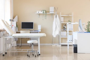 Modern çalışma yeri ve kanepesi olan doktorun ofisinin içi aydınlık.