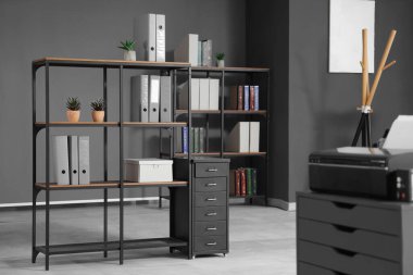 Raflar, çekmeceler ve yazıcılarla birlikte ofis içi.