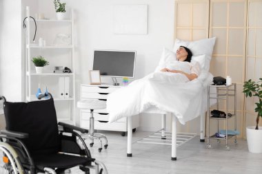 Hastane koğuşunda yatan genç bir kadın.