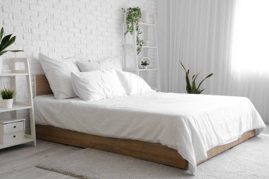 Rahat yatağı ve raf üniteleri olan modern yatak odası.