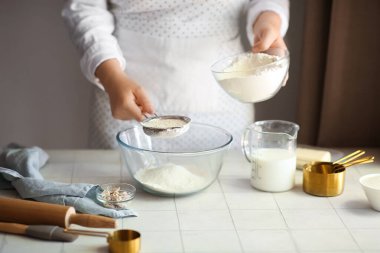 Kadın mutfakta geleneksel tarçınlı rulo hazırlıyor.