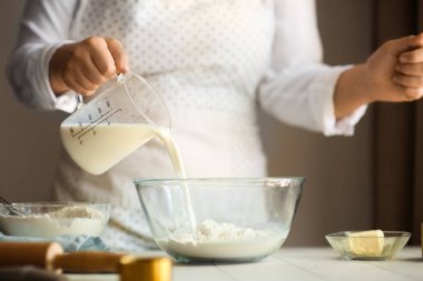 Kadın mutfakta geleneksel tarçınlı rulo hazırlıyor.