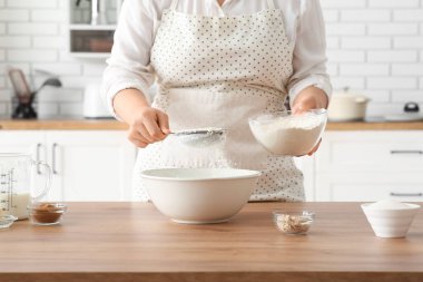 Kadın mutfakta geleneksel tarçınlı rulo hazırlıyor.
