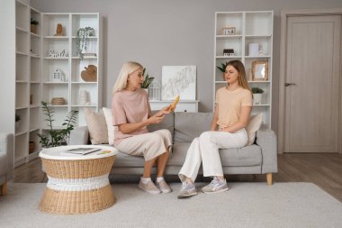 Prezervatifli bir anne, ergen kızıyla evde cinsel eğitim hakkında konuşuyor.