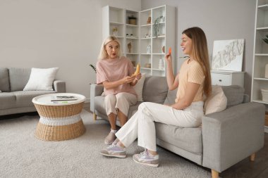 Prezervatifli bir anne, ergen kızıyla evde cinsel eğitim hakkında konuşuyor.