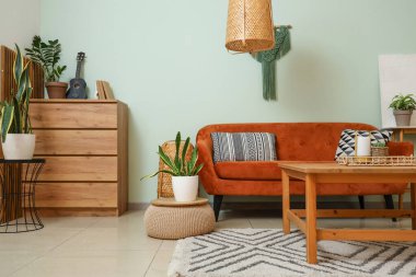 Oturma odasının içinde rahat bir kanepe ve ahşap bir masa.