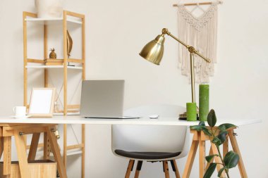 Masada raf ünitesi ve dizüstü bilgisayarı olan modern stil çalışma alanı.