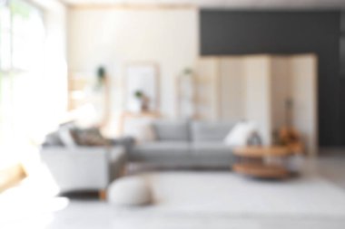 Gri kanepeleri ve kahve masası olan, bulanık manzaralı modern oturma odasının içi.