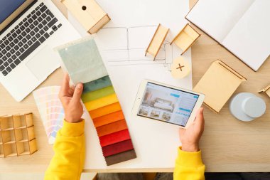 Kumaş örnekleri ve tablet bilgisayarı olan erkek mobilya tasarımcısı.