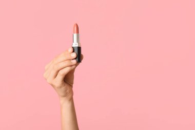 Pembe arka planda ruj izi olan bir kadın eli.