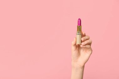 Pembe arka planda ruj izi olan bir kadın eli.