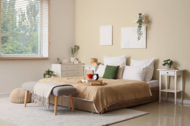 Masaları, bankları ve kahvaltısı olan şık bir yatak odası.