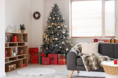 Gri kanepesi, Noel ağacı ve şenlikli süslemeleri olan oturma odasının içinde.