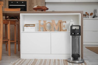 Mutfakta masanın yanında elektrikli ısıtıcı var.