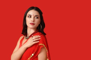 Kırmızı arka planda geleneksel sarili güzel bir Hintli kadın. Divaly kutlaması