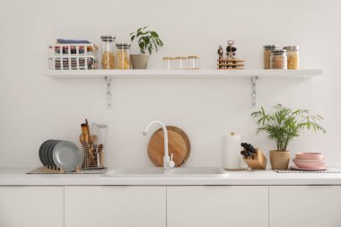 Lavabosu, rafı ve çatalı olan hafif mutfağın içi.