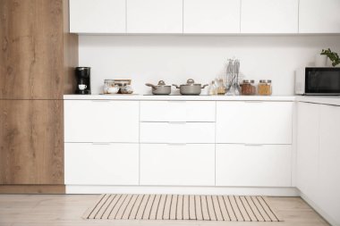 Beyaz tezgah ve çatal bıçaklarla aydınlık mutfağın içinde.