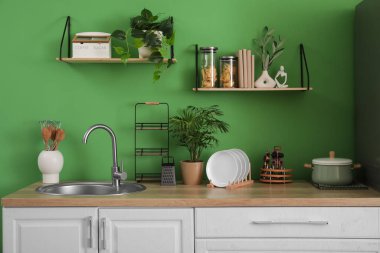 Mutfağın içinde tezgahlar, raflar ve çatallar var.