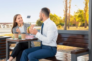 İş arkadaşları parkta öğle yemeği yiyor.