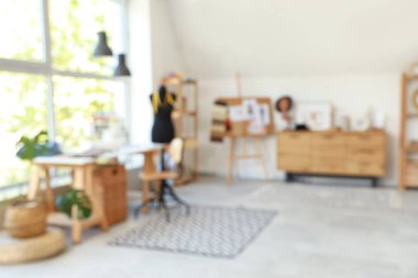 Moda tasarımcısının atölyesinin iş yeri, manken ve çekmeceleri bulanık görünüyor.