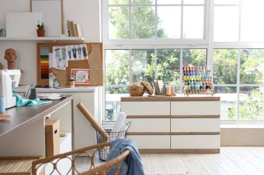 Moda tasarımcısının atölyesinin içinde iş yeri ve dikiş malzemeleri var.