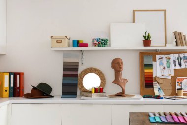 Moda tasarımcısının stüdyosundaki masa başında çivi ve dikiş malzemeleri.