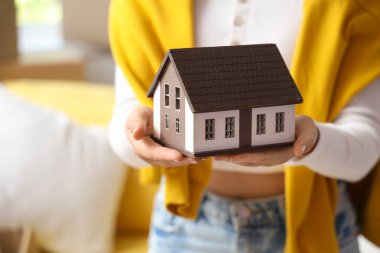 Taşındığı gün odada ev modeli olan genç bir kadın, yakın plan.