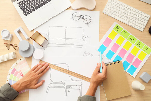 Рисунок дизайнера мужской мебели с линейкой на столе, вид сверху