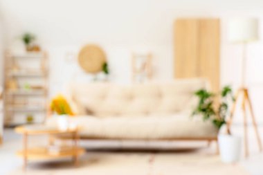 Kanepe, masa ve lamba ile aydınlık oturma odasını bulanık görmek