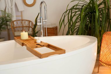 Odada yanan mum ve krema kavanozlarıyla dur.