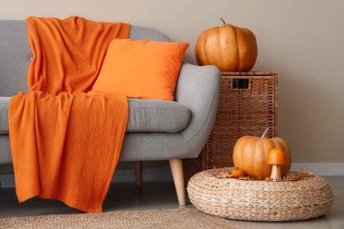 Kanepe, puf ve balkabaklı rahat bir oturma odası.