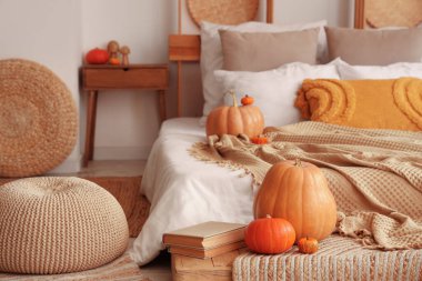 Sonbahar dekoru ve pufları olan rahat bir yatak odası.