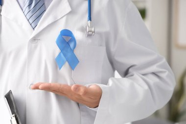 Klinikte mavi kurdeleli bir erkek doktor, yakın plan. Prostat kanseri farkındalığı