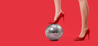 Yüksek topuklu kadın bacakları ve kırmızı zemin üzerinde disko topu ile metin için boşluk