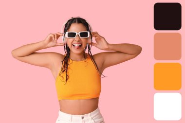 Harika bir Afro-Amerikalı kadın pembe arka planda müzik dinliyor. Farklı renk desenleri