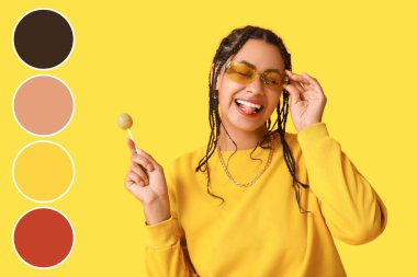 Sarı arka planda lolipopu olan havalı Afro-Amerikalı kadın. Farklı renk desenleri