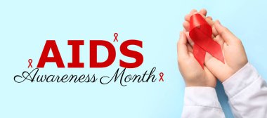 Açık mavi arka planda kırmızı kurdeleli eller. AIDS Farkındalık Ayı Afişi