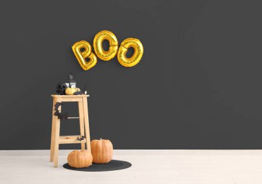 Tabure, balkabağı ve odanın duvarında asılı duran balonlardan yapılmış mesaj bülteni. Tasarım için pankart