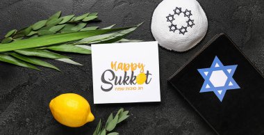 Dört tür (lulav, hadas, arava, etrog), Torah ve siyah grunge arka planda Mutlu SUKKOT yazılı tebrik kartı