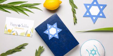 Dört türün (lulav, hadas, arava, etrog) yer aldığı Sukkot şenlik kompozisyonu, Tevrat ve ışık arkaplan üzerindeki tebrik kartı