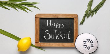 Four species (lulav, hadas, arava, etrog) and chalkboard with text HAPPY SUKKOT on light background clipart