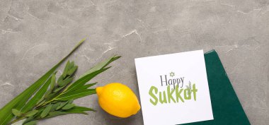 Four species (lulav, hadas, arava, etrog), Torah and greeting card with text HAPPY SUKKOT on grey grunge background with space for text clipart