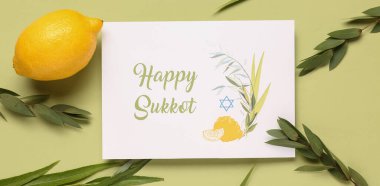 Dört tür (lulav, hadas, arava, etrog) ve yeşil arka planda Mutlu SUKKKOT yazılı tebrik kartı
