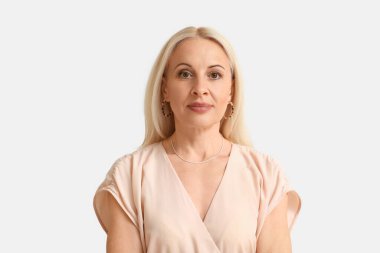 Mature blonde woman on light background