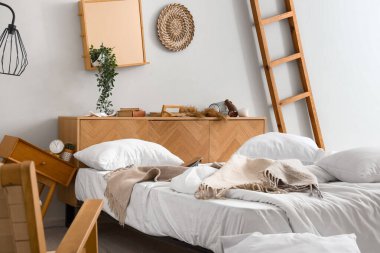 Yatak ve komodinli dağınık bir yatak odası.