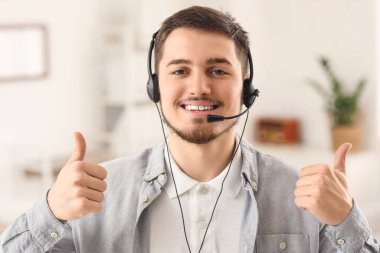 Erkek teknik destek ajanı ofiste baş parmağını kaldırıyor