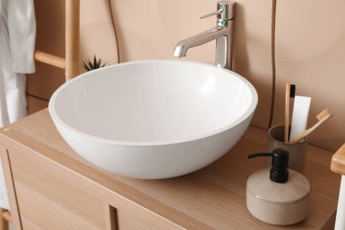 Banyo aksesuarlı lavabo lavabosu banyodaki masada.