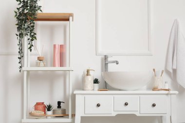 Banyo aksesuarlı lavabo lavabosu banyodaki masada.